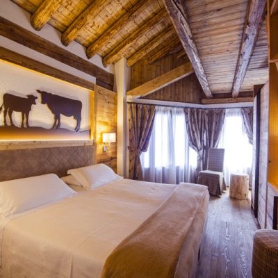 Camera da letto accogliente con arredamento in legno e decorazioni a tema bovino. Camera da letto accogliente con arredamento in legno e decorazioni a tema bovino.
