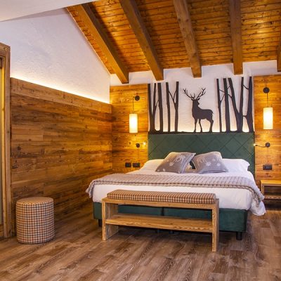 Camera da letto accogliente con arredamento in legno e decorazione a tema cervi. Camera da letto accogliente con arredamento in legno e decorazione a tema cervi.