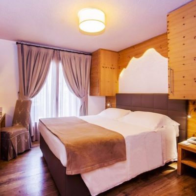 Camera d’albergo accogliente con letto matrimoniale, arredamento in legno e luce calda. Camera d'albergo accogliente con letto matrimoniale, arredamento in legno e luce calda.